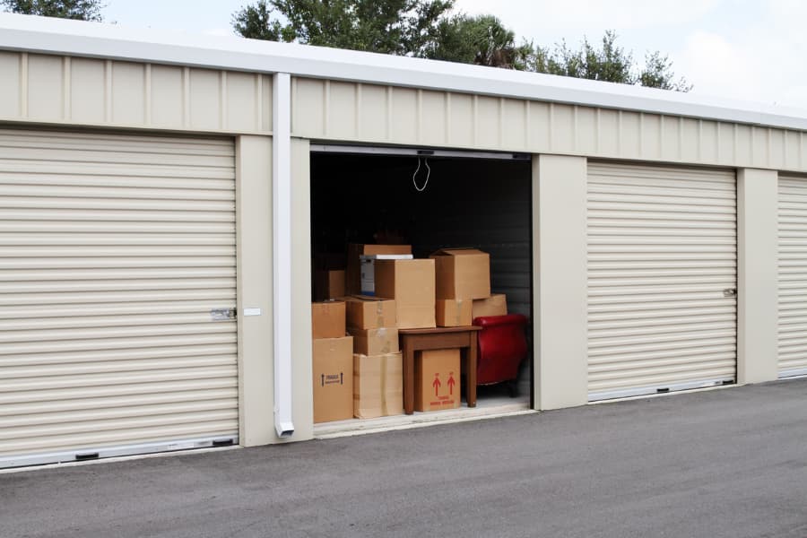 self-storage facility with one door open showing boxes and furniture in doorway