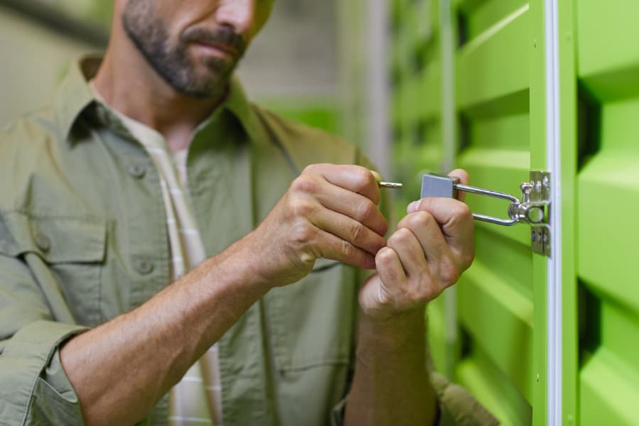 Man putting secure lock on self-storage locker