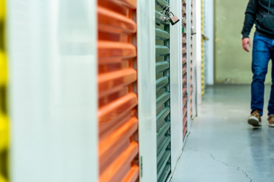 Unknown man walking in a corridor full of storage units