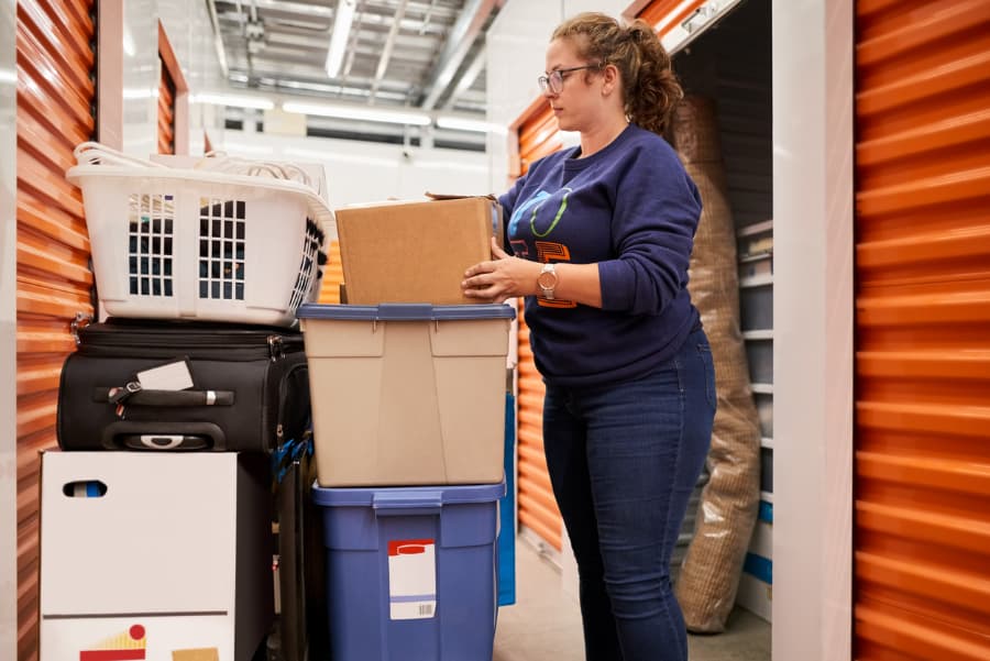 Woman moving boxes into a self storage unit